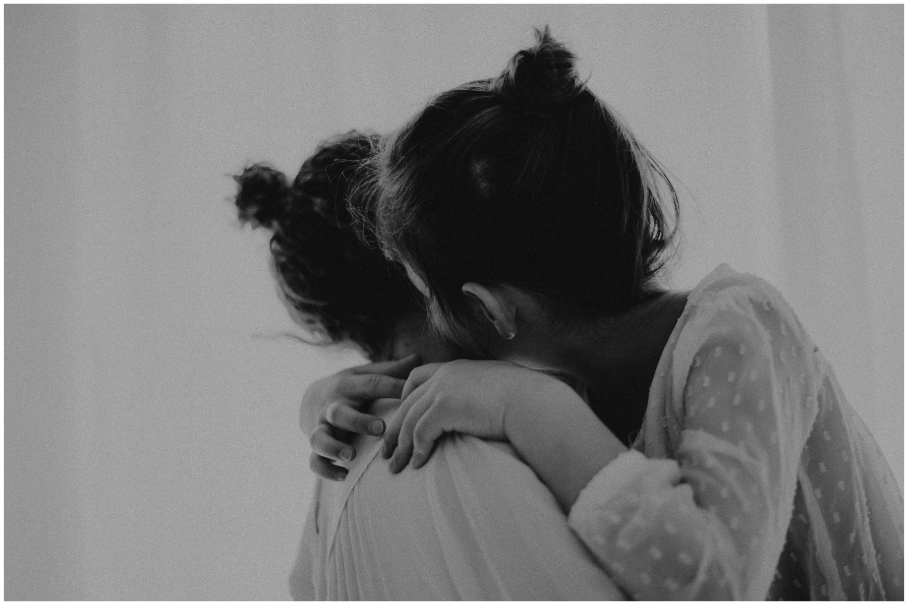 Photo d'une maman avec sa fille dans les bras lors d'une séance photo avec grain de clic photographie