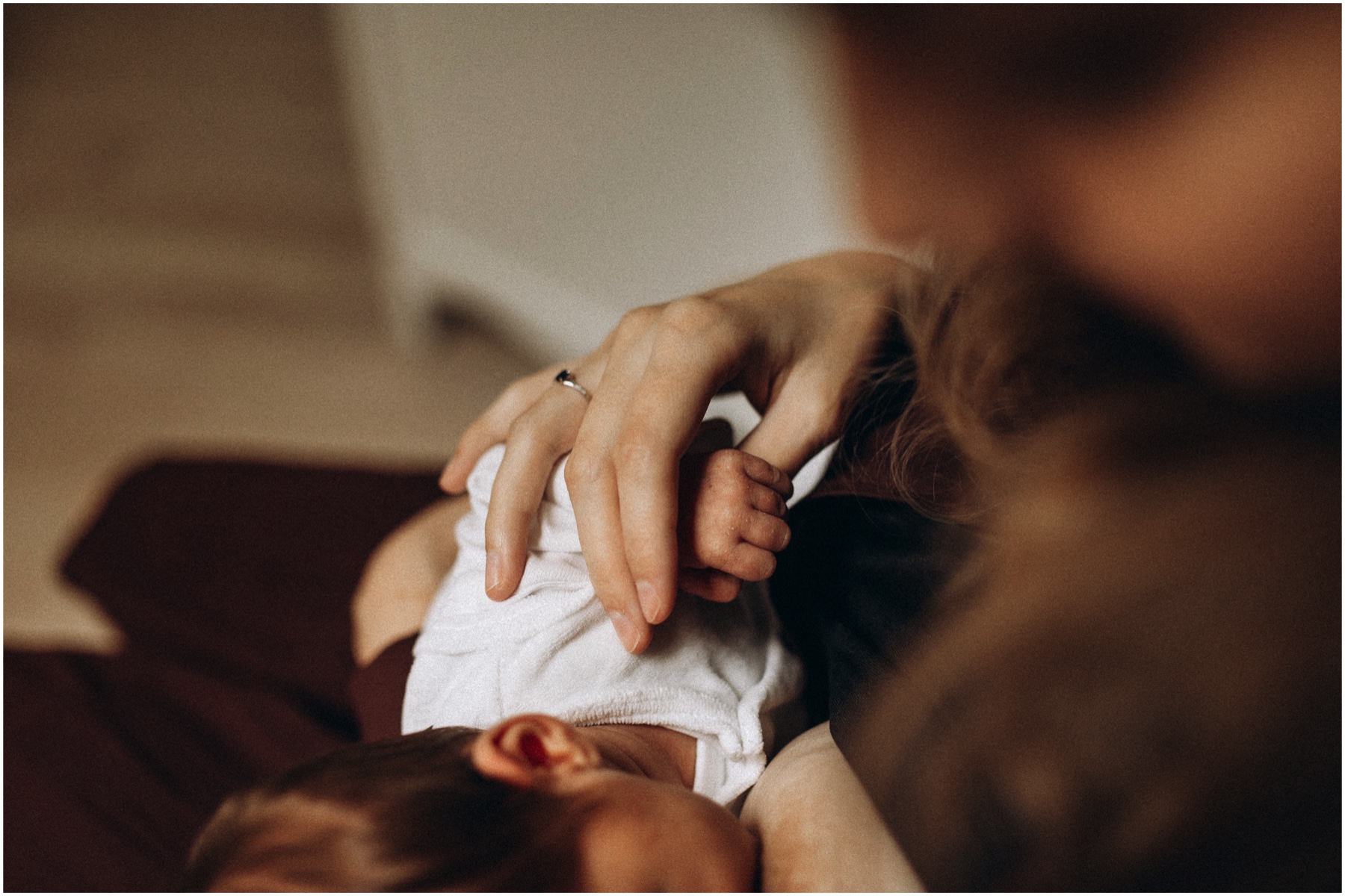 Photo d'une maman qui allaite son bébé lors d'une séance photo avec une photographe toulousaine