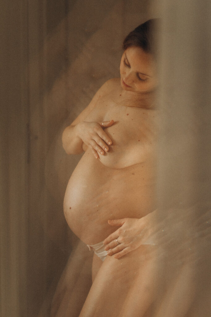 Femme enceinte dénudée posant lors d'une séance photo.
