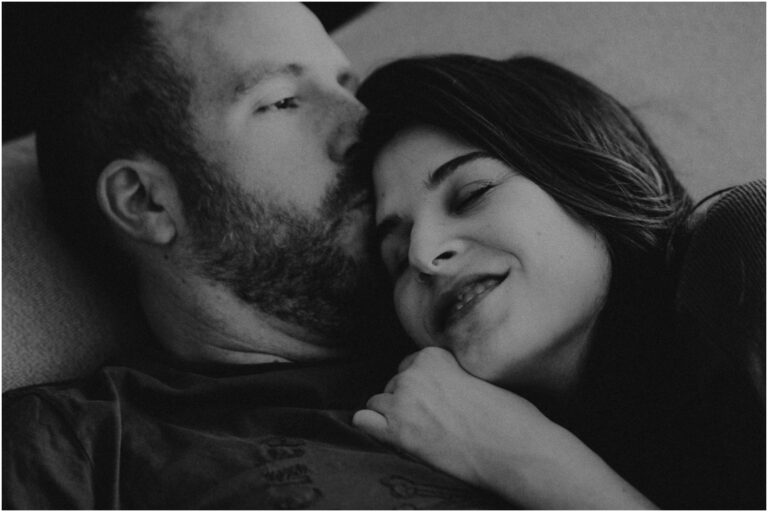 Un homme et une femme enlacés allongés sur le lit.