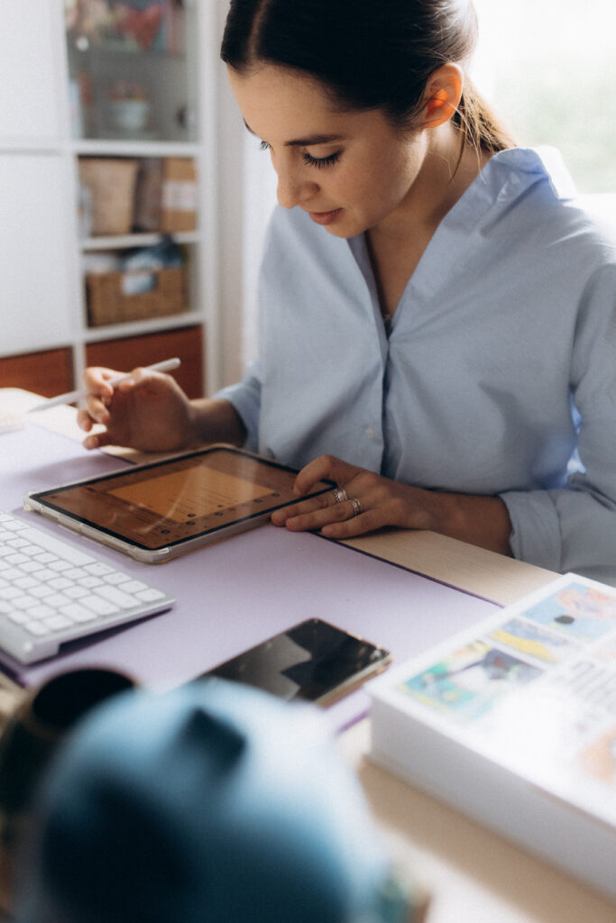 Une femme avec une chemise bleue travaille sur une tablette.