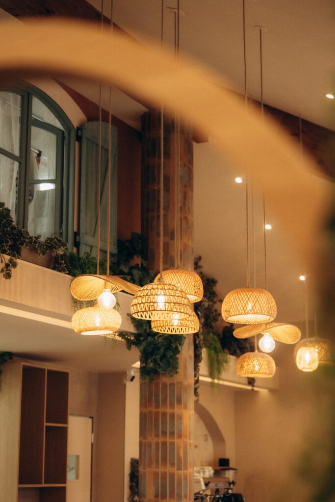 Des luminaires en rafia disposés en nombre au plafond.