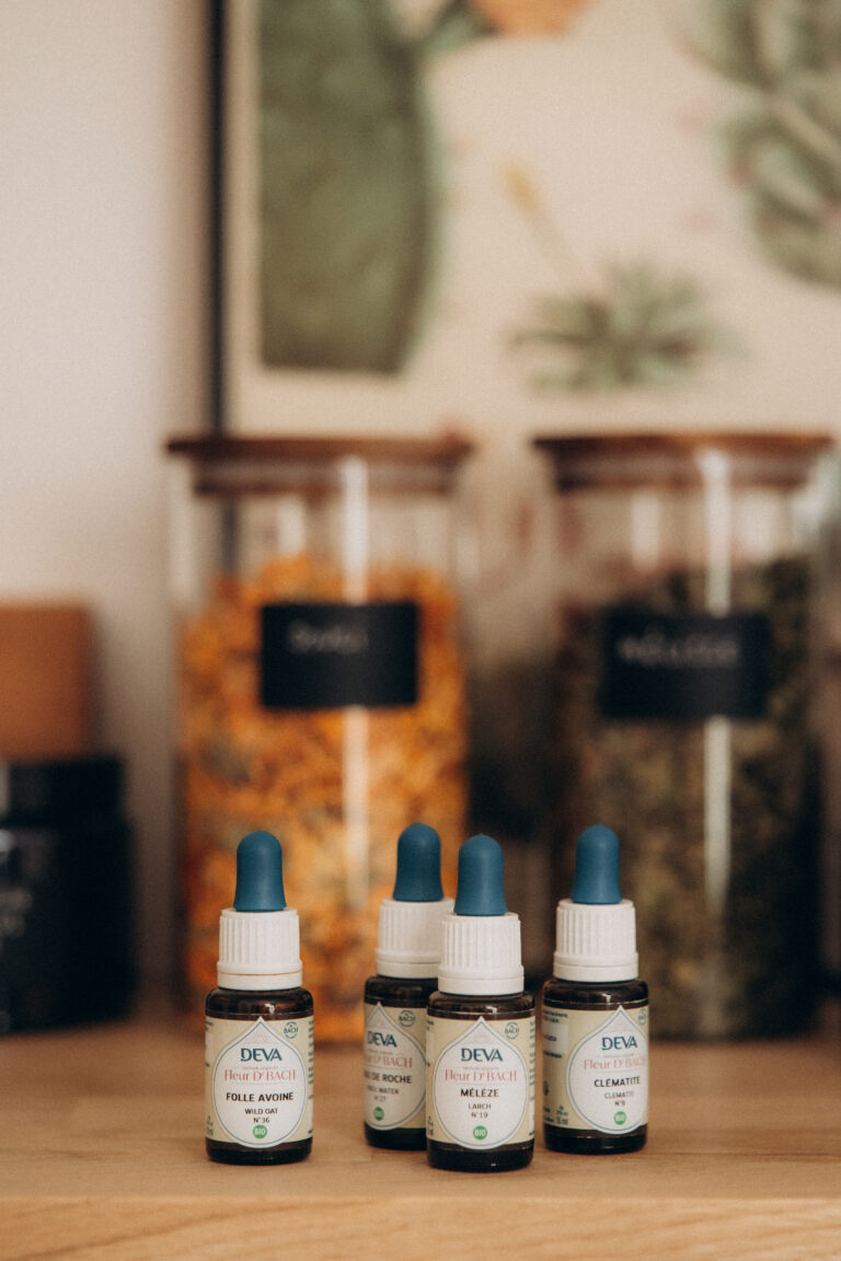 Quatre huiles essentielles posées sur une commode en bois.
