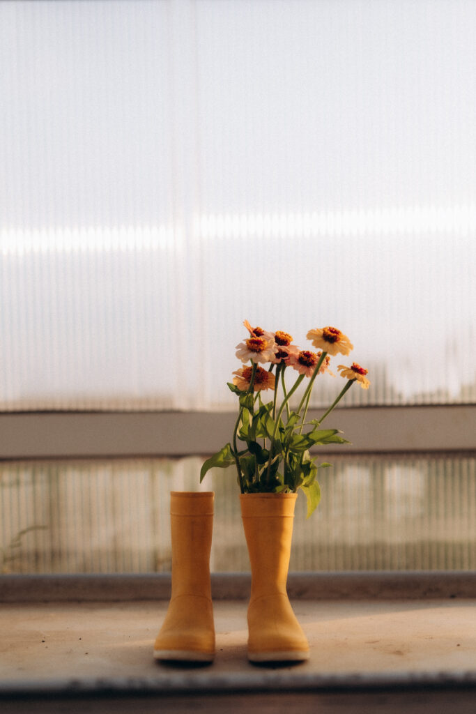 Des bottes d'enfant jaunes remplit de fleurs coupées.