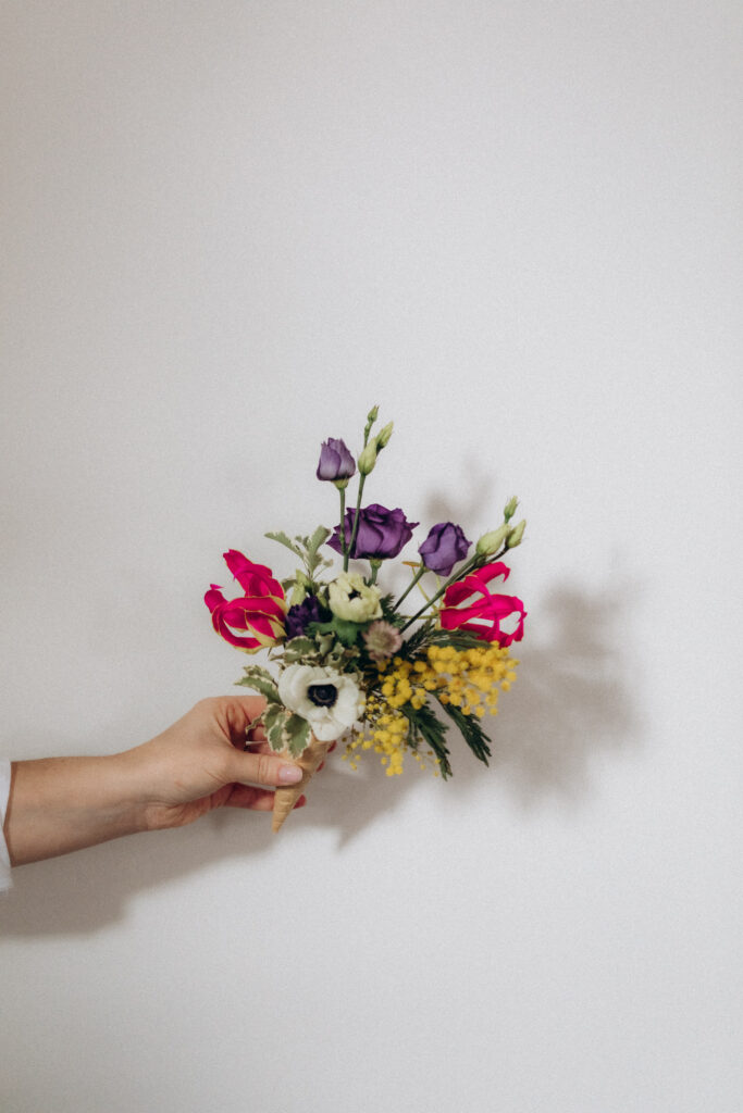 Une main tenant un bouquet très coloré.