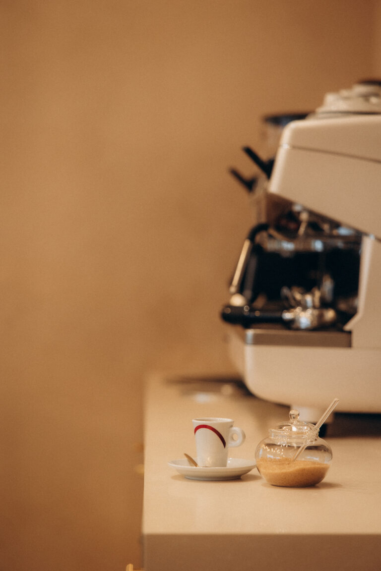 Une cafetière professionnelle avec des tasses disposées devant.