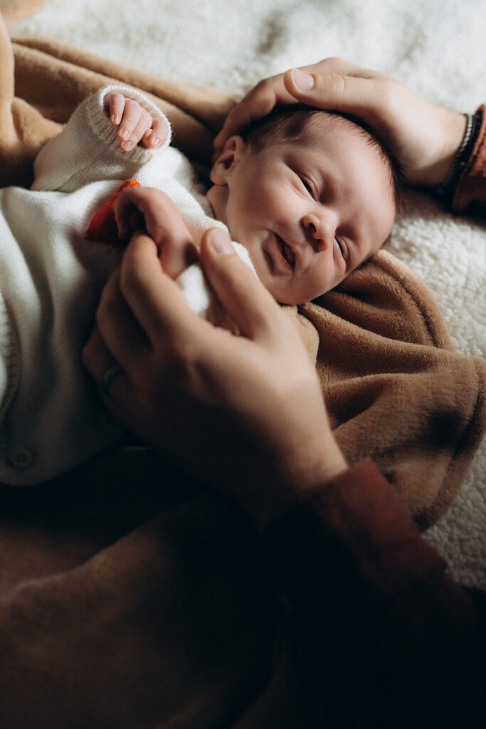 Un bébé endormi posé sur un lit.