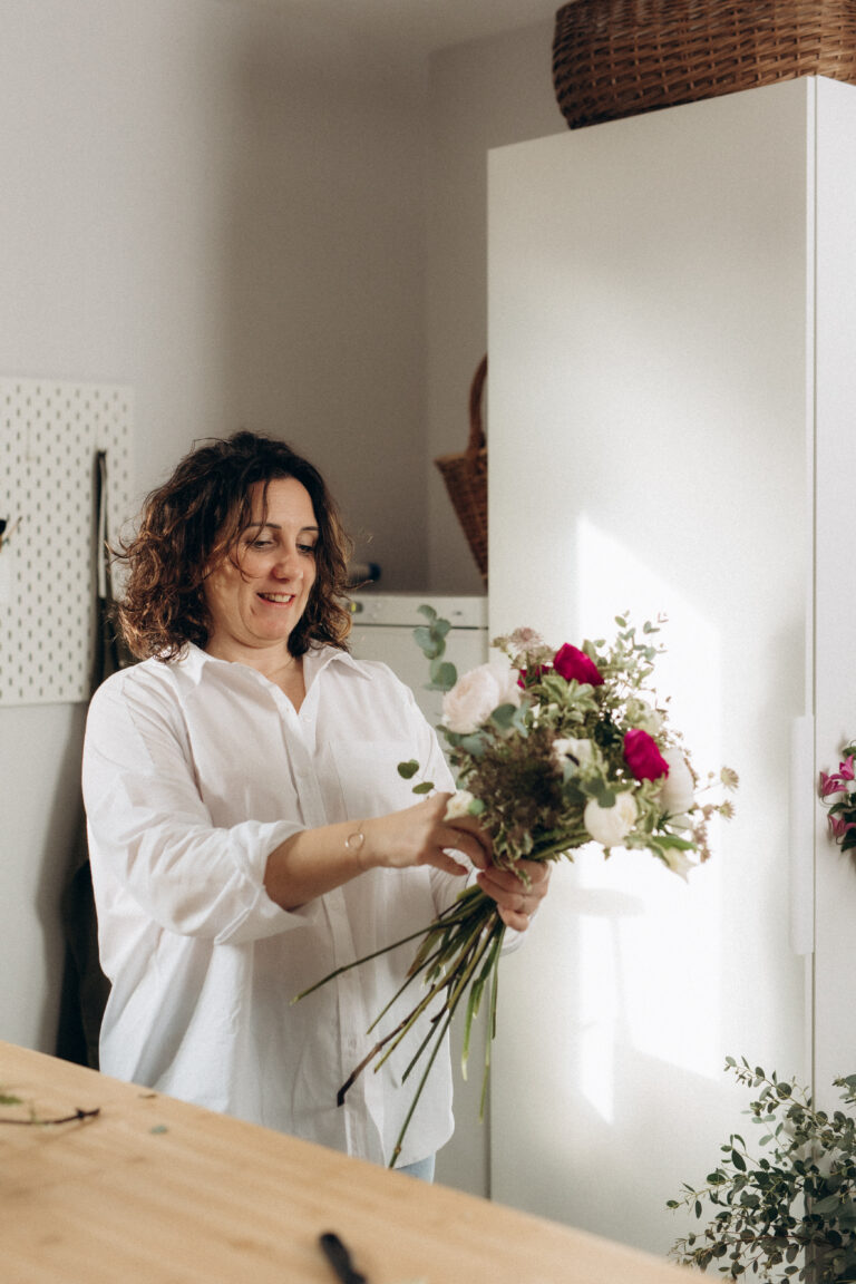 Une femme tenant un bouquet de fleurs.